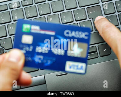 Hand typing on laptop keyboard credit card number shopping or buying on line concept Stock Photo