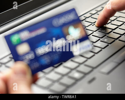 closeup hand holding and using credit card typing on keyboard laptop Stock Photo