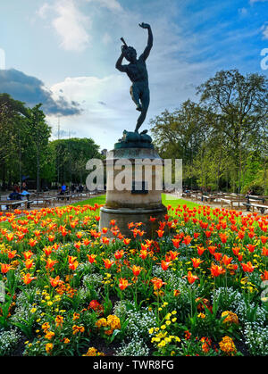 Le faune dansant-Jardin (translation The dancing fauna) sculptureu in Luxembourg Garden. Beatiful Tulips Paris France Stock Photo