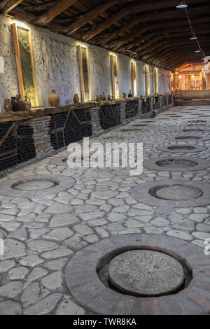 KVARELI, GEORGIA - OCTOBER 01, 2018: Making wine at traditional Georgian technology in large clay jugs kvevri, buried in the ground. Plant of Kindzmar Stock Photo