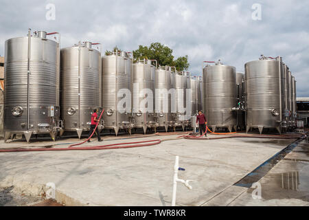 KVARELI, GEORGIA - OCTOBER 01, 2018: Workers near fermentation tanks for wine production outdoors in yard of the plant Kindzmarauli Corporation Stock Photo