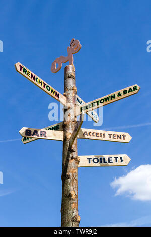 A wooden finger post or way marker giving directions at the Africa Oye music festival in Sefton Park, Liverpool, Merseyside, UK Stock Photo