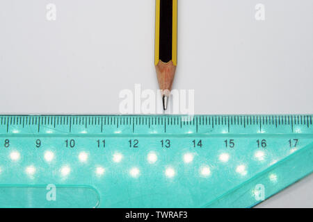 Old used triangle ruler and a pencil. Ruler and pencil.