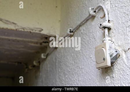 Old electrical installation in a detached house. Light switch in the basement. White background. Stock Photo