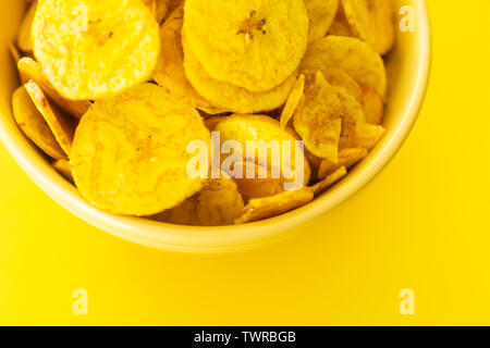 Baked Plantain Chips in Yellow bowl - a healthy snack Stock Photo