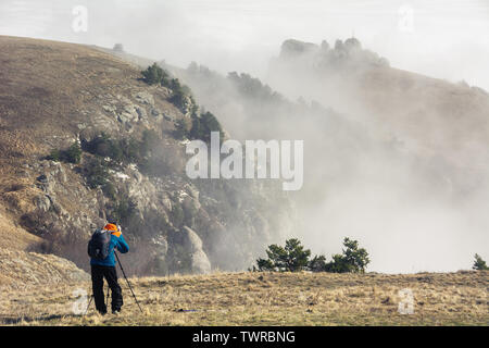 Alushta, Republic of Crimea - March 1, 2019: A photographer takes pictures of a beautiful mountain landscape with clouds on Demerdzhi Stock Photo