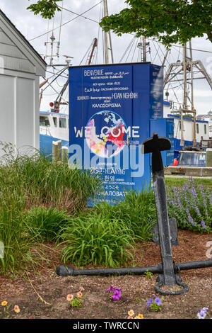 Hyannis, MA - June 10, 2019: Sign at the harbor says welcome in many languages from around the world. Stock Photo