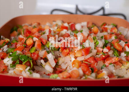 Pico de gallo simmering in a clay frying pan Stock Photo