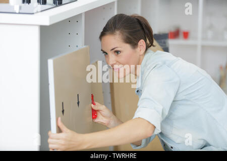 young woman using electric screwdriver to installation Stock Photo