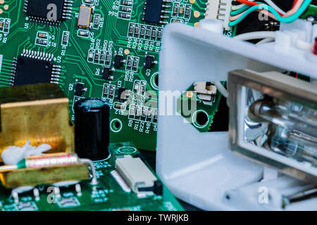 A Macro image of Circuit boards and other components of a broken-down photographer’s flash in repair.  The components are in sharp focus at center fra Stock Photo