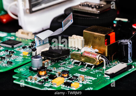 A Macro image of Circuit boards and other components of a broken-down photographer’s flash in repair.  The components are in sharp focus at center fra Stock Photo