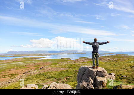 Freedom man in nature on iceland with arms enjoying free happiness in beautiful icelandic landscape.