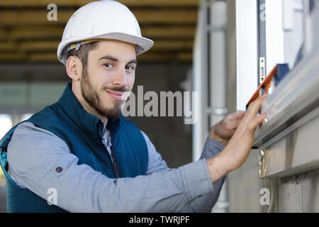 workman measuring window frame Stock Photo