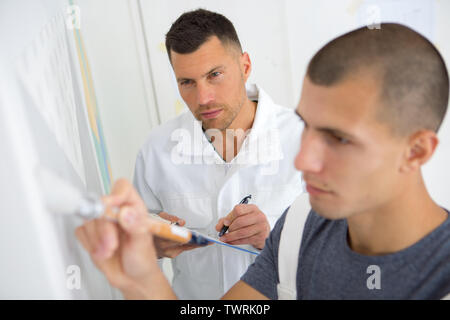 supervisor assessing trainee painter Stock Photo