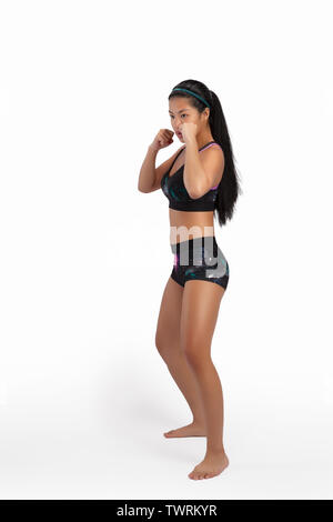 An Asian Female Model in Yoga and Martial Arts Pose Wearing Sports Bra and Shorts Stock Photo