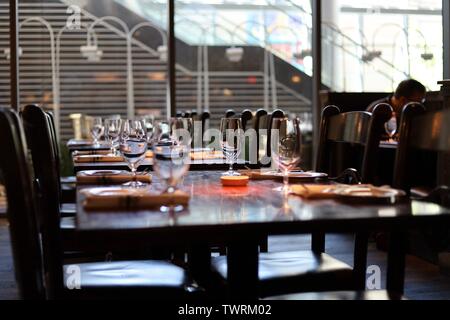 An empty table inside a restaurant with wine glasses and napkins set Stock Photo