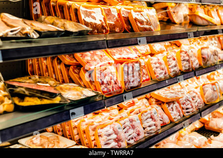 meats packed and stacked on the shelves of the supermarket for retail sale of great variety Stock Photo