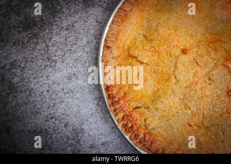 Homemade rustic apple pie on rock black background. Stock Photo