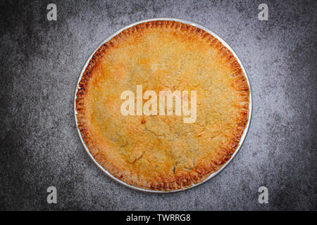 Homemade rustic apple pie on rock black background. Stock Photo