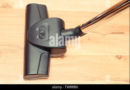 Closeup of head of modern vacuum cleaner on wooden floor background Stock Photo