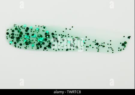 Transparent sparkle glitter green paint stroke isolated on white background close up view Stock Photo