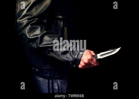 Teen threatened with a knife on the street, night lighting. Stock Photo