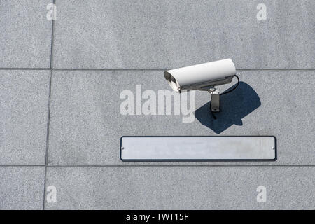 White camera security (CCTV) setting with blank plate on wall Stock Photo