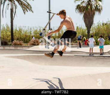 Boy doing sport with scooter in skate park Stock Photo
