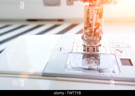 Close up sewing machine at tailor workplace. Sew process. - needlework, craft, sewing and tailoring concept. Stock Photo