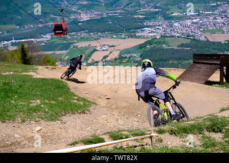 Maribor, Slovenia - May 2, 2019: Downhill mountain bikers riding down the trail on Pohorje near Maribor, Slovenia. Pohorje bike park is very popular Stock Photo