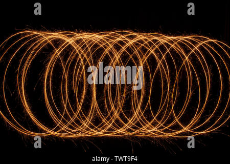 Sparkle golden glowing shiny spiral lines and circle light effect. Abstract Glowing light fire ring trace. Stock Photo
