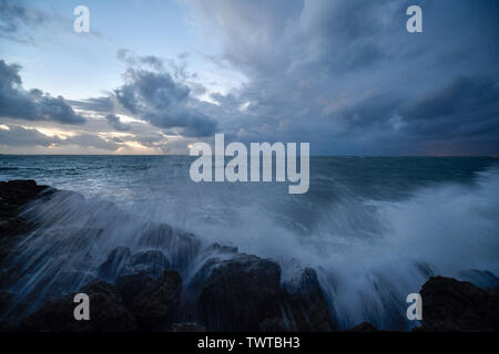 Waves crashing over breakwall breakwater Stock Photo