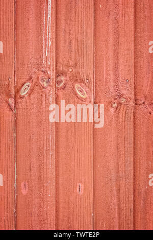 Semi-abstract vertical, red-stained, wooden fence slats; portrait format. Stock Photo