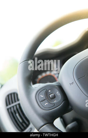 Close up of a steering wheel with remote control, blurry dashboard Stock Photo