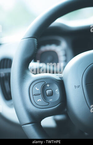 Close up of a steering wheel with remote control, blurry dashboard Stock Photo