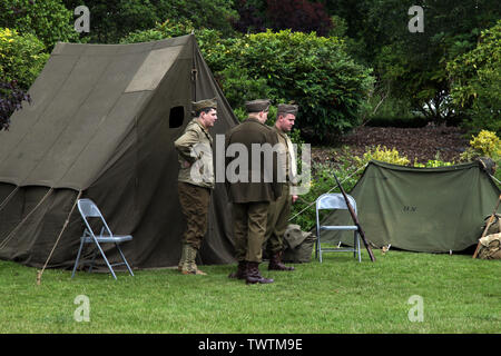 Three ww2 army reenactment soldiers standing around outside army tents at Home Front Festival, 2019 Stock Photo