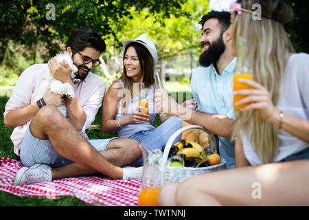 Happy friends in the park having picnic on a sunny day. Stock Photo