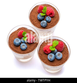 Classic tiramisu dessert with blueberries and raspberries in a glass isolated on a white background with clipping path Stock Photo