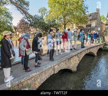 Group of tourists visiting Bourton on the Water. Stock Photo