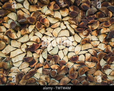 Closeup pattern of a stack of split logs, old dusty firewood. Pile texture of dry chopped wood. Winter fuel for stove heating. Stock Photo