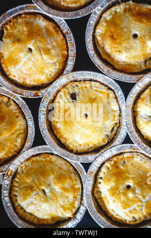 closed mini-quiche quiche stuffed with meat and mushrooms, fruits, cherries on a dark background. top view. Stock Photo