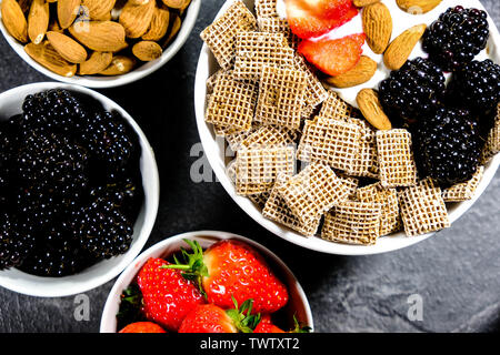 Healthy Breakfast Cereals With Fresh Fruit , Shreddies, or Shredded Wheat,Strawberries, Blackberries, Almonds and Yogurt. Stock Photo