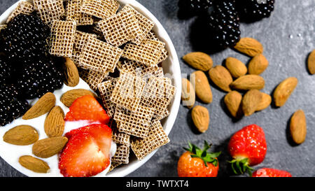 Healthy Breakfast Cereals With Fresh Fruit , Shreddies, or Shredded Wheat,Strawberries, Blackberries, Almonds and Yogurt. Stock Photo