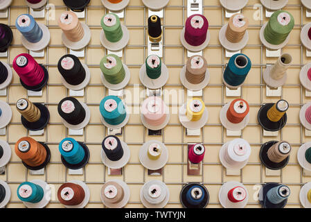 Spools of thread hanging in a tailor shop. Skeins for sewing machine hang in a sewing shop. close photo. Stock Photo
