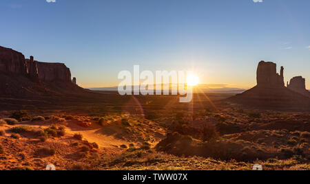 Monument Valley at sunrise. Navajo Tribal Park in the Arizona-Utah border USA. Sun rising behind the red rocks, clear sky background Stock Photo