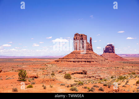 Monument Valley, Navajo Tribal Park in the Arizona-Utah border, United States of America. Red rocks against blue sky background Stock Photo