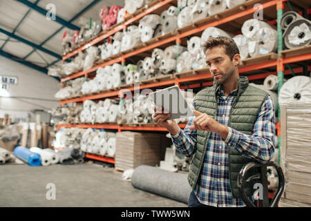 Warehouse worker using a digital tablet to check stock Stock Photo