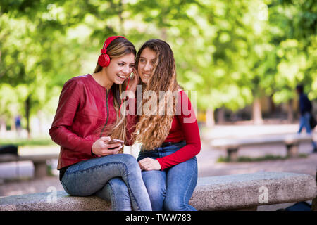 Smiling teenagers listening music together from phone Stock Photo