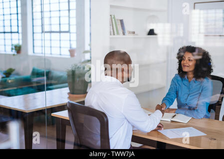 Smiling office manager shaking hands with a staff member Stock Photo