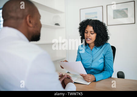 Manager reading a resume during an interview in her office Stock Photo